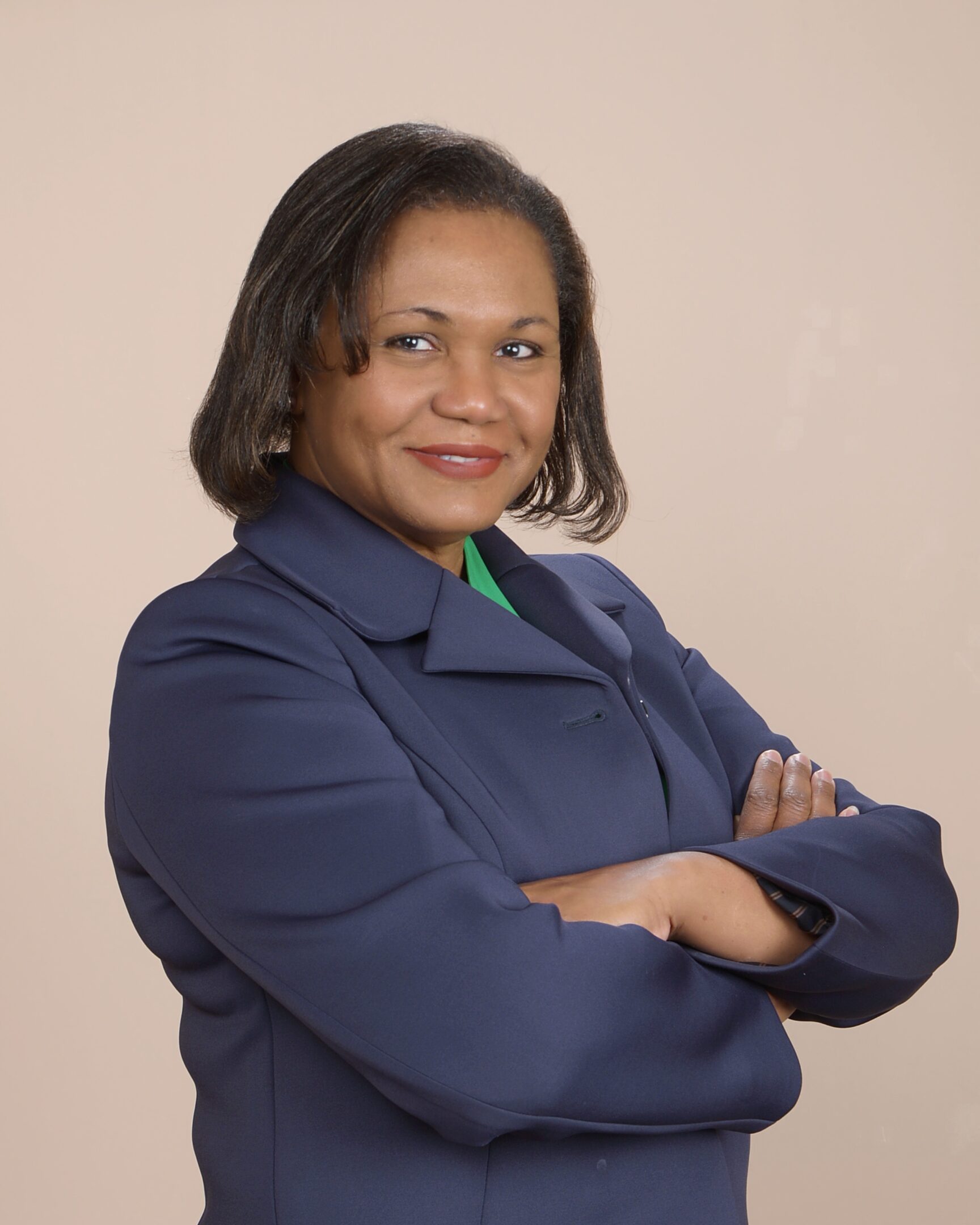 Confident woman in professional attire posing with arms crossed.